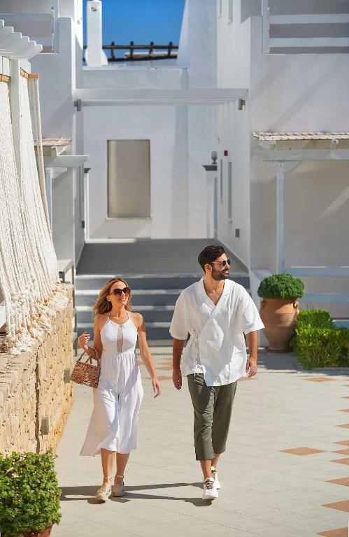 a man and a woman walking down a sidewalk at Perigiali in Skiros