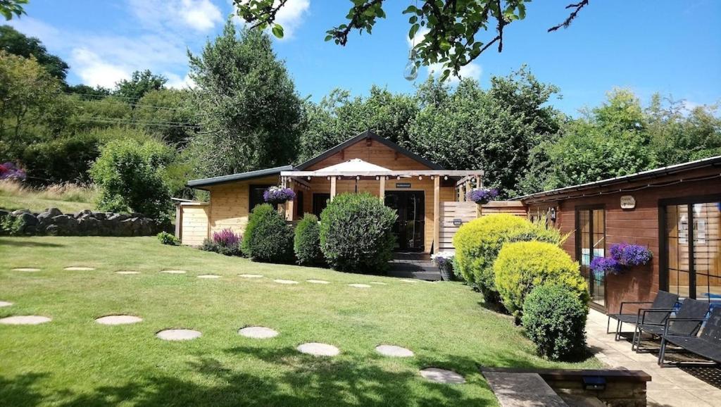 En have udenfor 'Monktonmead Lodge' in secluded setting, with private indoor pool.