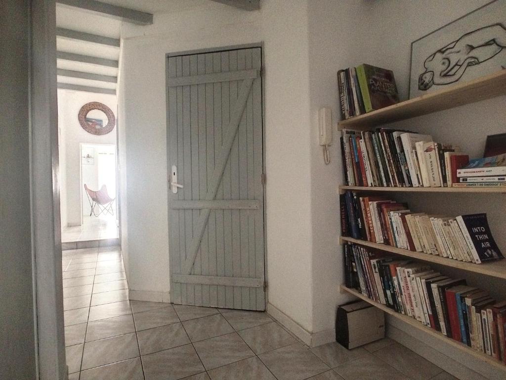 a hallway with a door and a book shelf with books at Rare maison à 50m de la plage. Grande terrasse vue mer. in Palavas-les-Flots