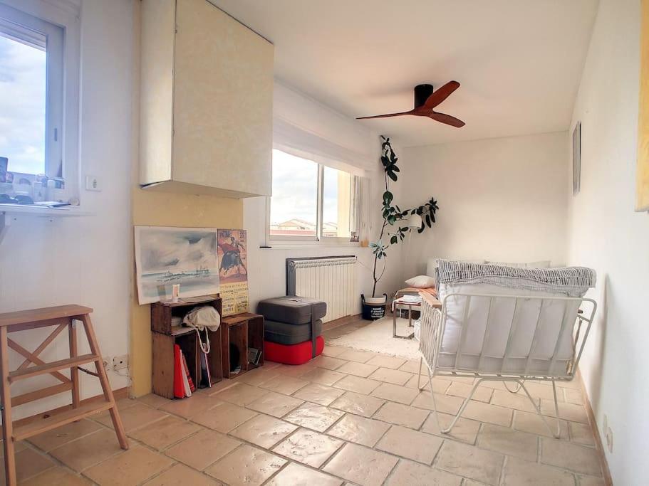 a living room with a ceiling fan and a couch at Rare maison à 50m de la plage. Grande terrasse vue mer. in Palavas-les-Flots