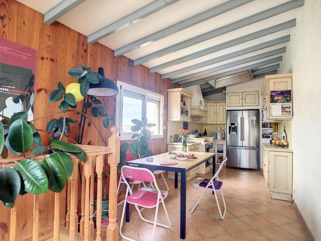 a kitchen with a table and pink chairs at Rare maison à 50m de la plage. Grande terrasse vue mer. in Palavas-les-Flots