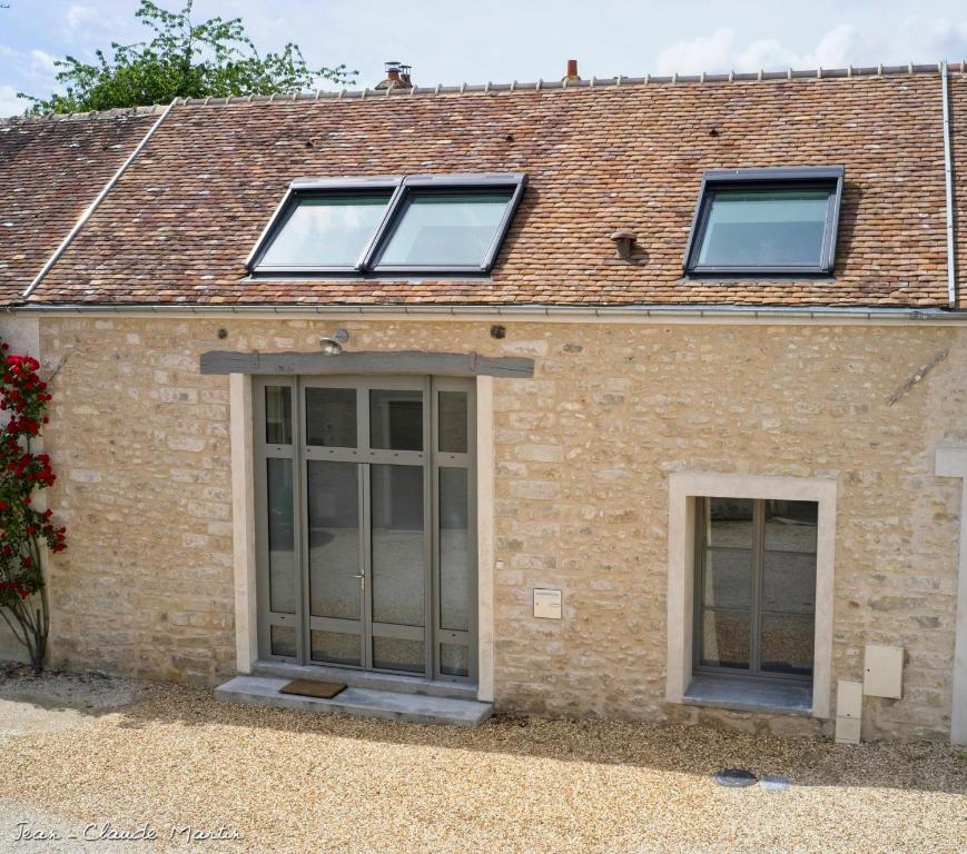 une maison avec deux fenêtres et un toit dans l'établissement Gite Oliveira's, à Ury