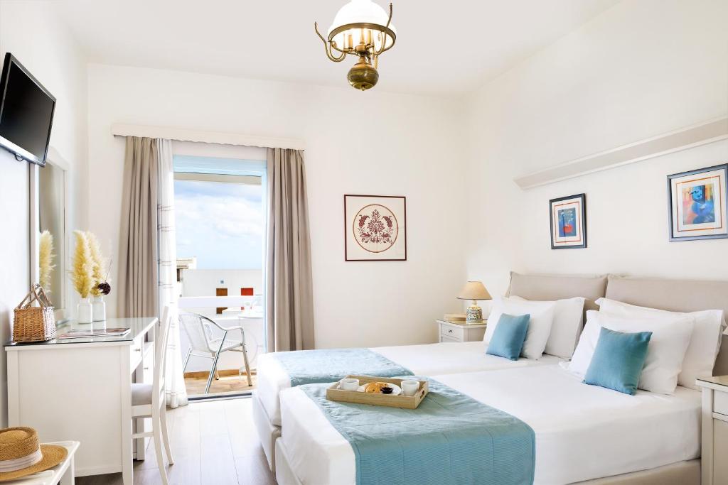 a white bedroom with a bed with a tray on it at Perigiali in Skiros