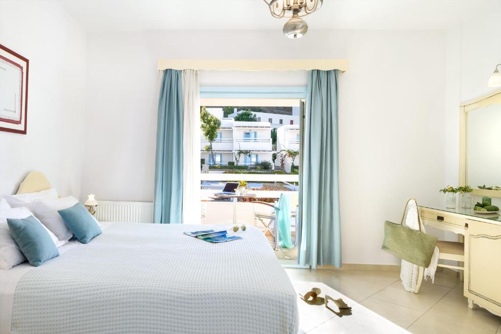 a bedroom with a bed and a desk and a window at Perigiali in Skiros