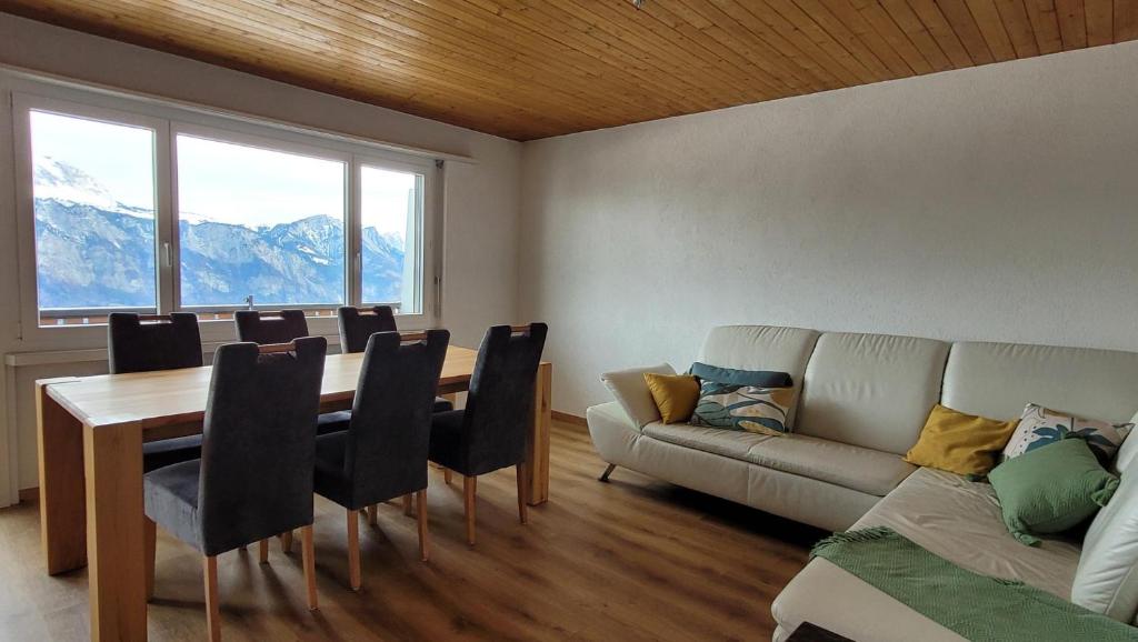 sala de estar con mesa y sofá en Ferienwohnung an der Prodalp Talstation, en Flumserberg