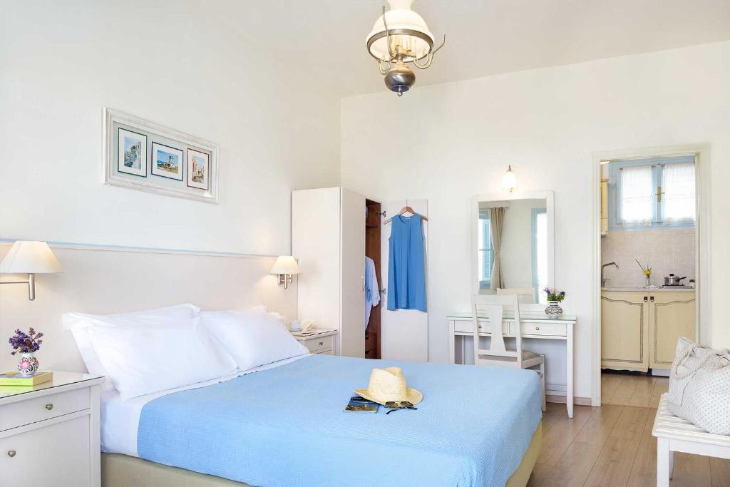 a bedroom with a blue bed and a bathroom at Perigiali in Skiros