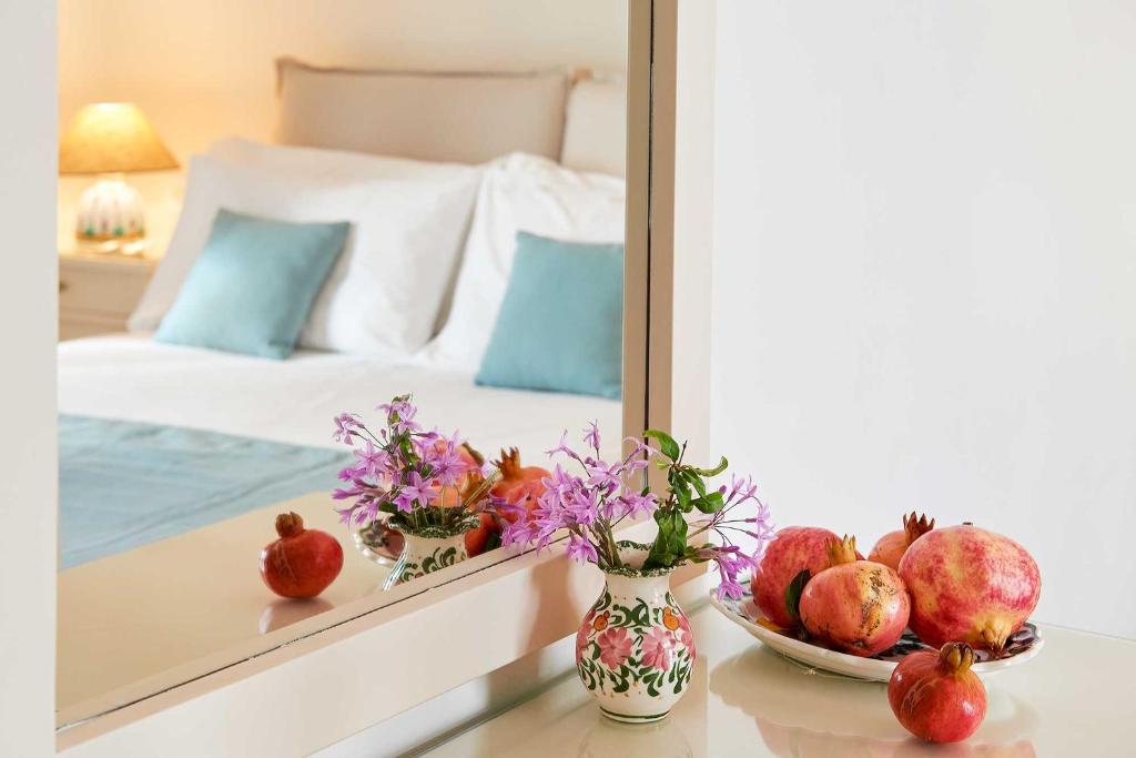 a mirror reflecting a bedroom with a bed and a bowl of fruit at Perigiali in Skiros
