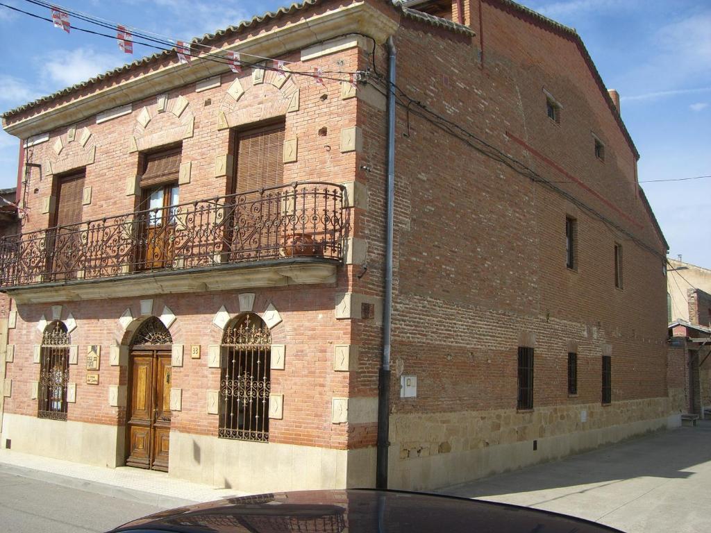 a brick building with a balcony on the side of it at Casa Rural El Saúco in La Vellés
