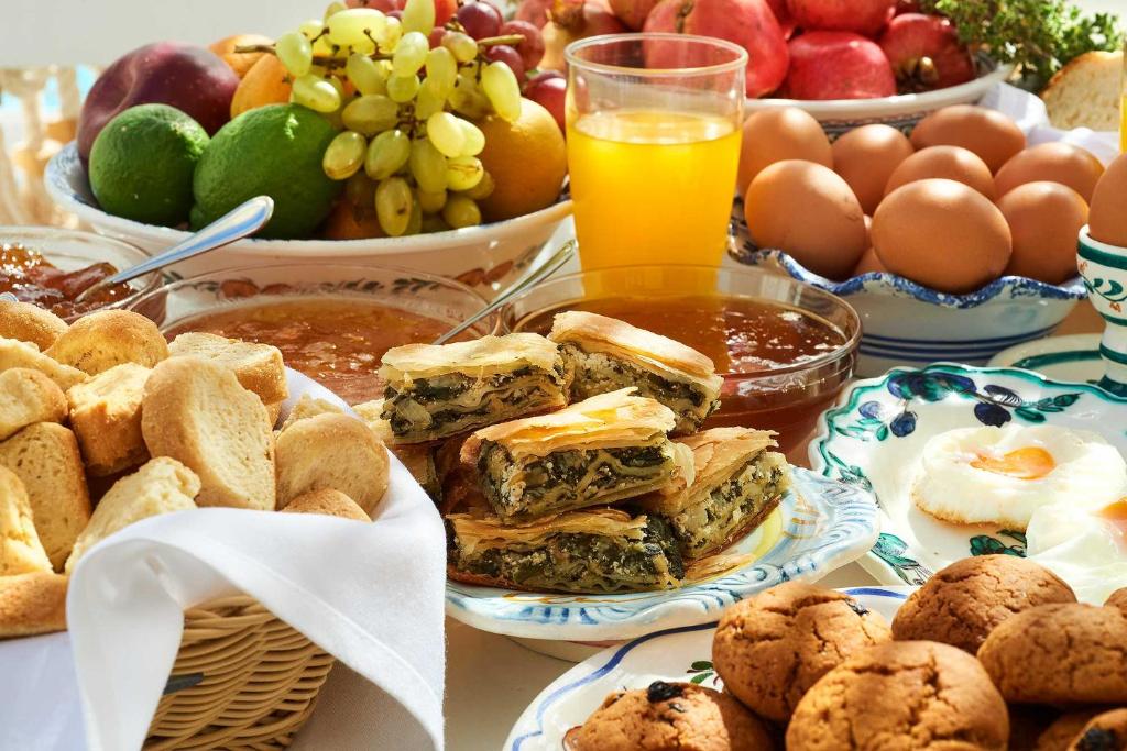 a table topped with plates of food and fruit at Perigiali in Skiros