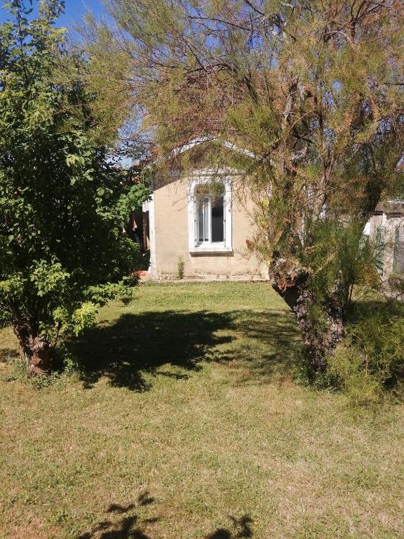 une vieille maison avec un arbre dans la cour dans l'établissement Meublé de tourisme courts séjours déplacements professionnels, à Ruelle-sur-Touvre