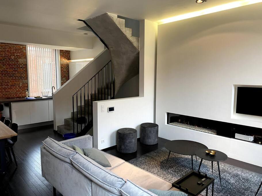ein Wohnzimmer mit einem Sofa und einer Treppe in der Unterkunft Uniek verblijf op rustige, kindvriendelijke site in Ostende