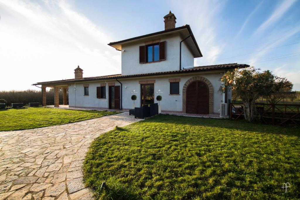ein Haus mit einem grünen Garten davor in der Unterkunft agriturismo villa amerina in Corchiano