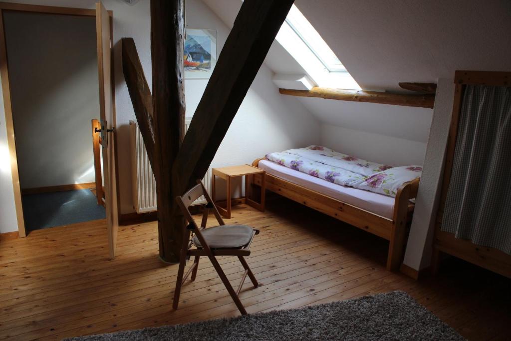 um quarto com uma cama, uma cadeira e uma janela em Up Höcht em Osteel
