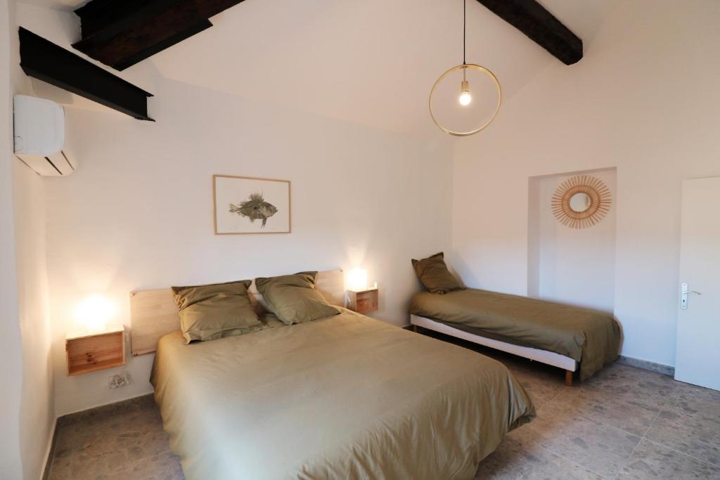 a bedroom with a large bed and a night stand at Appartements à la ferme in La Ciotat