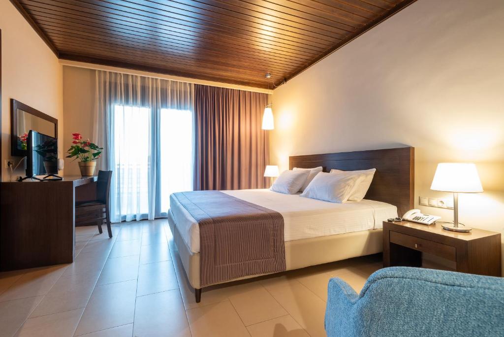 Agios Ioannis KaspakaにあるPorto Plaza Hotelのベッドルーム(ベッド1台、テレビ、ソファ付)