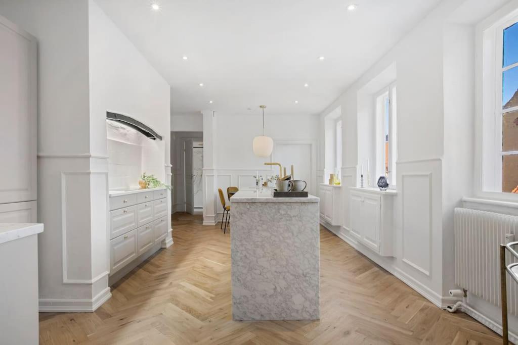 a kitchen with white cabinets and a counter top at Amazing apartment in the center of Helsingør in Helsingør