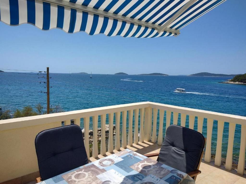 d'un balcon avec une table et des chaises donnant sur l'océan. dans l'établissement Blaža, à Prvić Luka