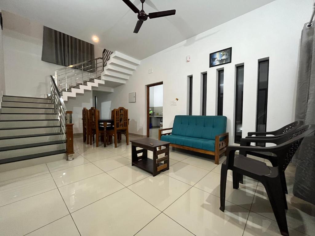a living room with a blue couch and a table at HOLLYWOOD Villa in Sultan Bathery