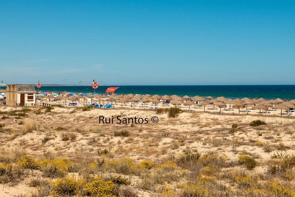 una playa con una fila de sillas y el océano en Manta Villa 2, en Manta Rota