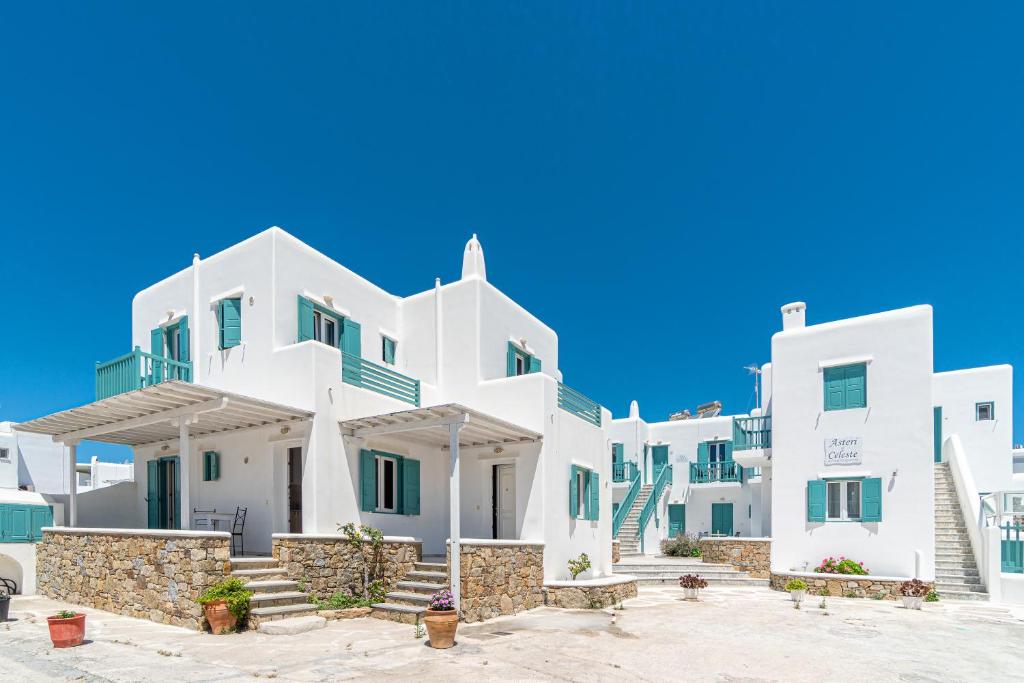 a row of white buildings with blue sky in the background at Ornos Apartments in Ornos