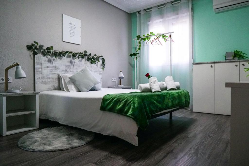 a bedroom with a large bed with a green blanket at Bioparco Apartment in Valencia