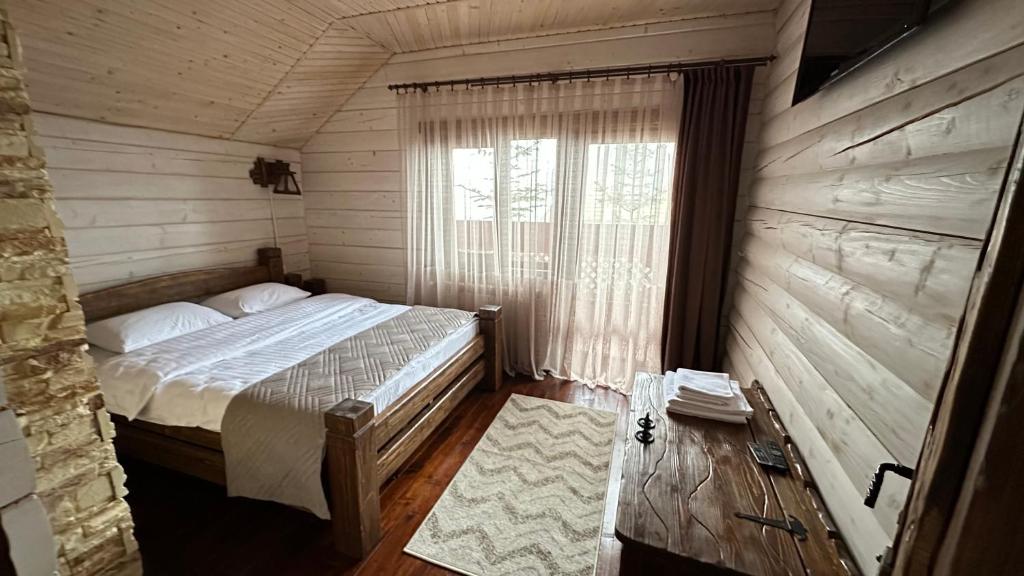 a bedroom with a bed in a room with a window at Forest House in Migovo