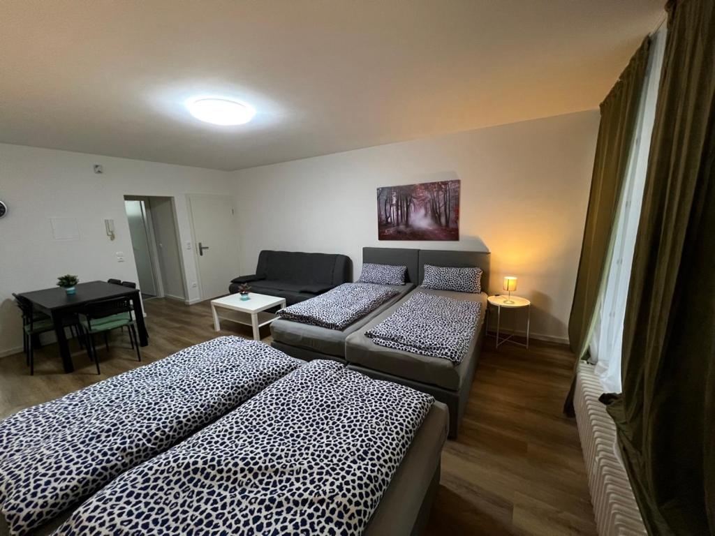 een woonkamer met 2 bedden en een bank bij Wohnung in Troisdorf T03 in Troisdorf