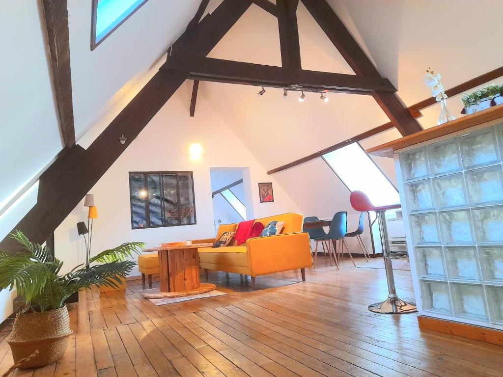 een woonkamer met een bank en een tafel bij Le Nid d'hirondelles - Appartement de caractère hypercentre au calme in Bourges