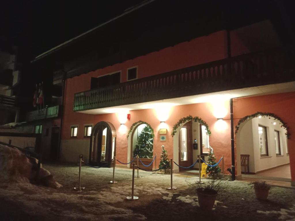ein Gebäude mit Weihnachtsbäumen in der Nacht davor in der Unterkunft Oberthaler Hotel in Sappada