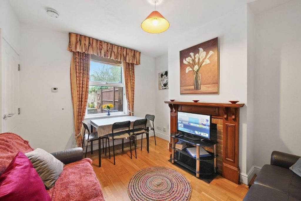Comfortable 2 bedroom property, Maidstone في ميدستون: غرفة معيشة بها أريكة وتلفزيون وطاولة