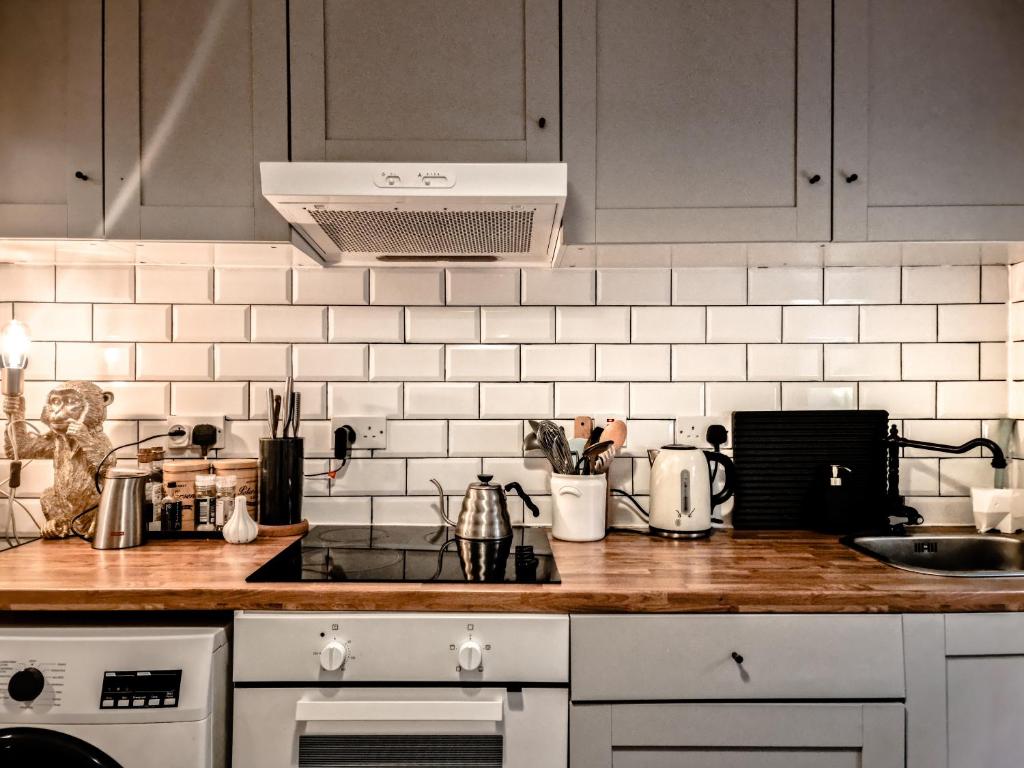 cocina con electrodomésticos blancos y encimera en Whole Stylish Apartment 1880s Guinness Worker House en Dublín