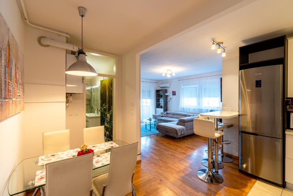 kuchnia i salon ze szklanym stołem i krzesłami w obiekcie Flexible SelfCheckIns 40 - Zagreb - Parking - Big Loggia - New - 2 beedroms w Zagrzebiu
