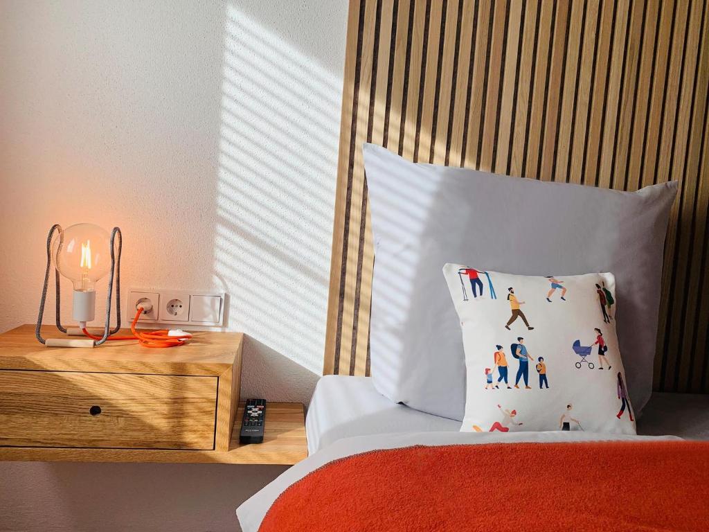 een slaapkamer met een bed met een kussen en een nachtkastje bij Dorf(er)leben Ferienwohnung im Kleinwalsertal in Mittelberg