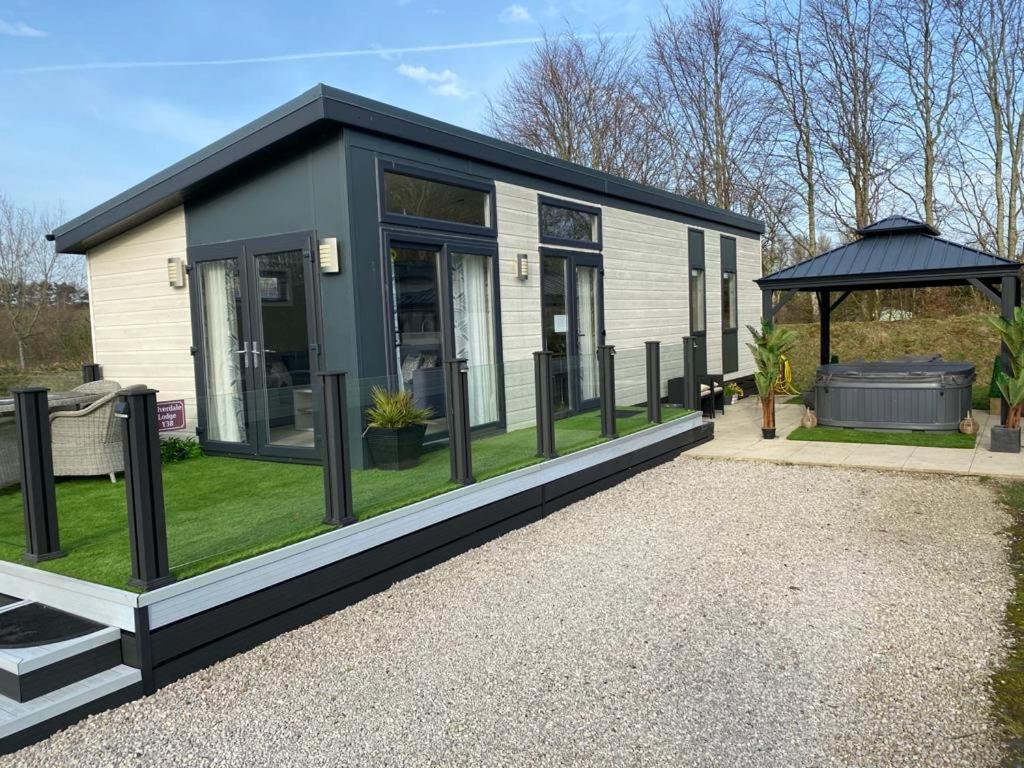 a black and white tiny house with a gazebo at Silverdale Lodge Hot Tub & Wifi in Warton