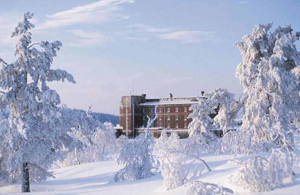 ein Gebäude im Schnee mit schneebedeckten Bäumen in der Unterkunft Sälens Högfjällshotell in  Högfjället