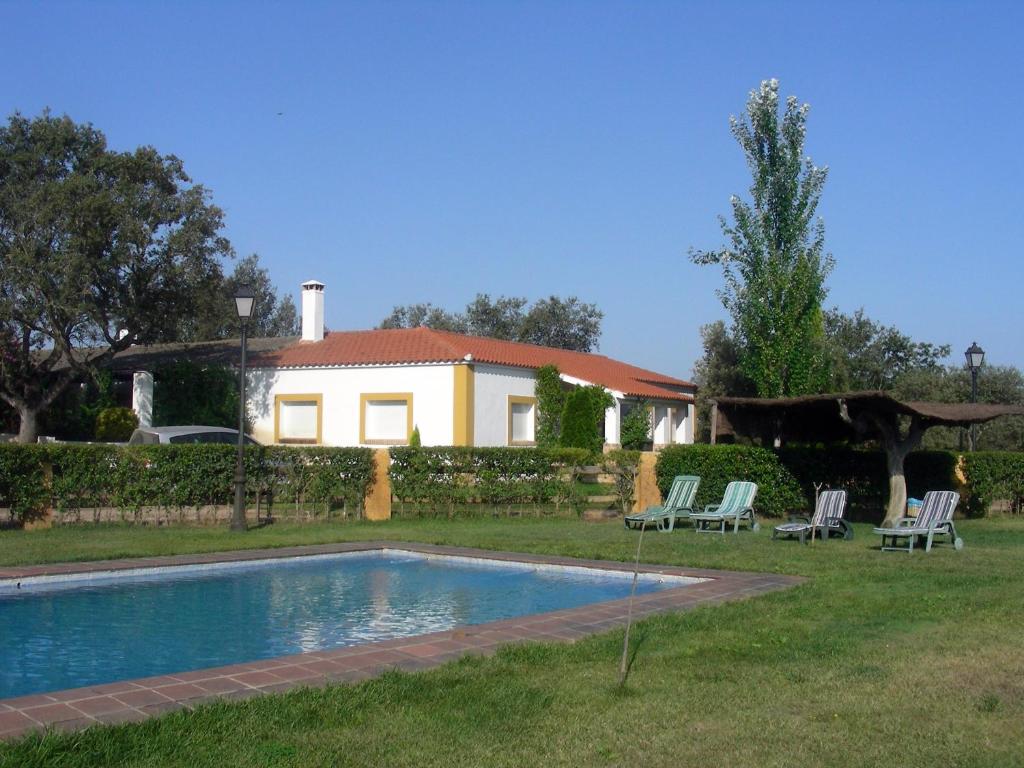 una casa con piscina en el patio en Finca Dehesa Tres Riveros en Herrera de Alcántara