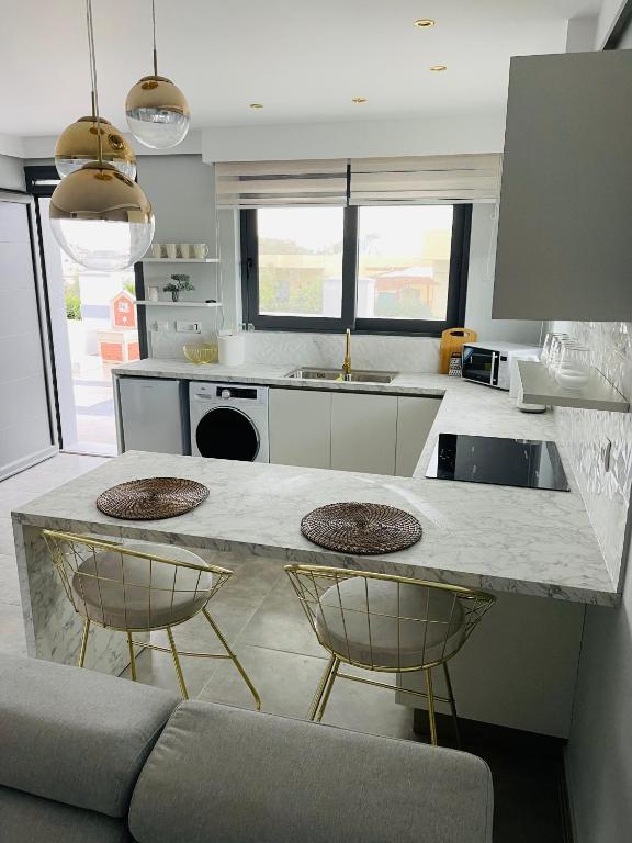 kuchnia z blatem z 2 stołkami barowymi w obiekcie Vixen Apartment w mieście Theologos