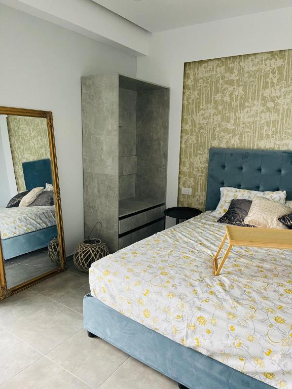 sypialnia z niebieskim łóżkiem i lustrem w obiekcie Vixen Apartment w mieście Theologos