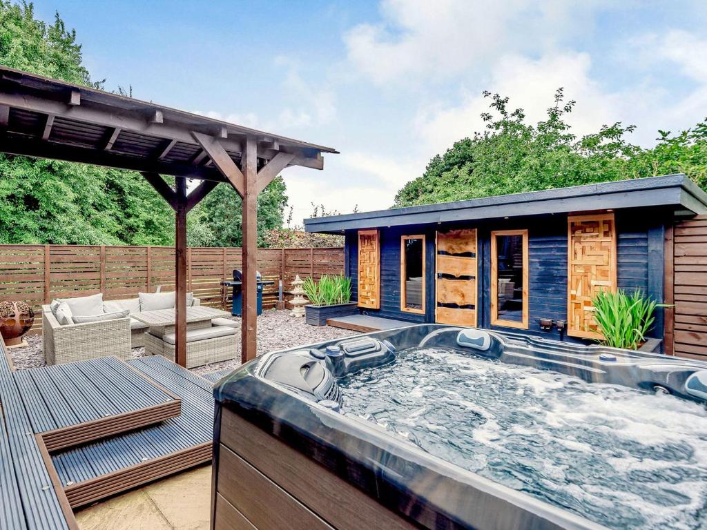 una bañera de hidromasaje en un patio con una casa en Orchard Retreat, en Kirton