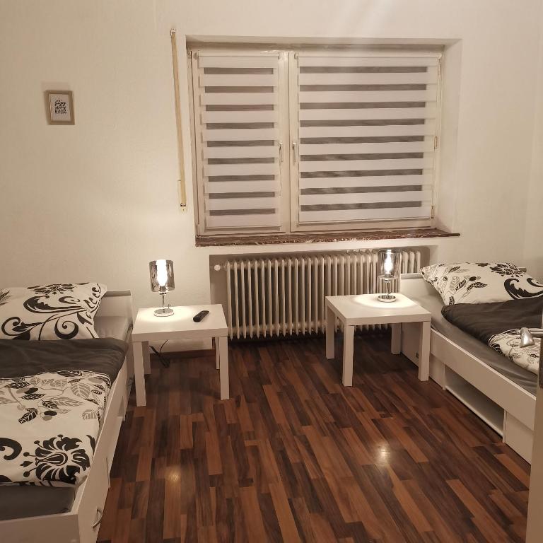 a room with two beds and a window and two tables at Ferienunterkunft Sson in Detmold