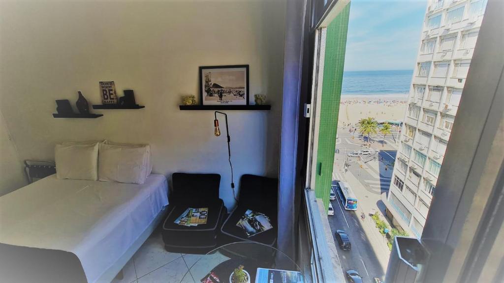a bedroom with a bed and a view of the beach at Studio_Copa_Clara in Rio de Janeiro