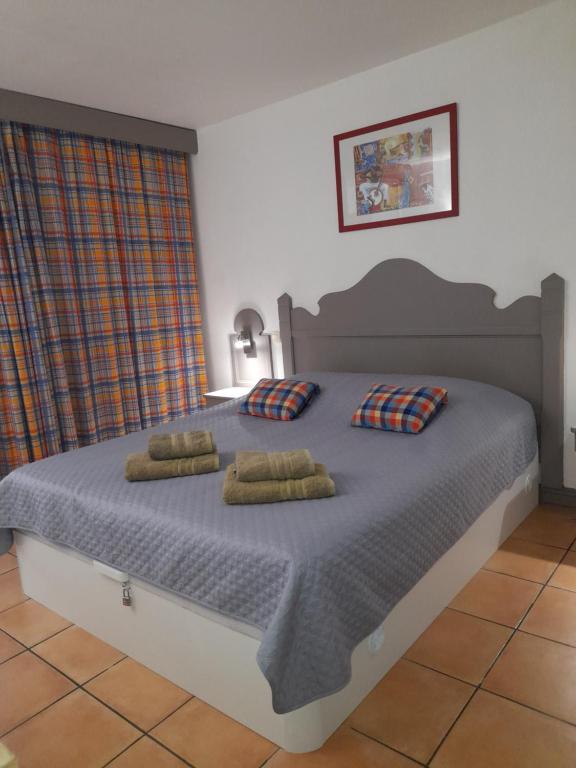 une chambre avec un grand lit avec deux oreillers dans l'établissement MANOU, à Sainte-Anne