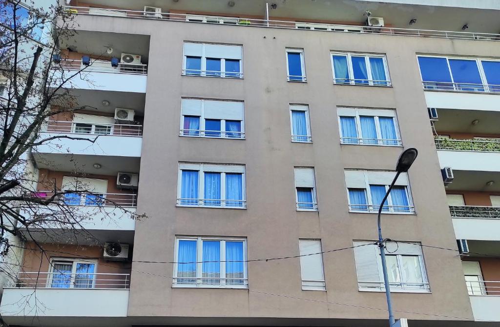 ein Apartmenthaus mit blauen Fenstern und einem Straßenlicht in der Unterkunft Apartman Jevrejska Banja Luka in Banja Luka