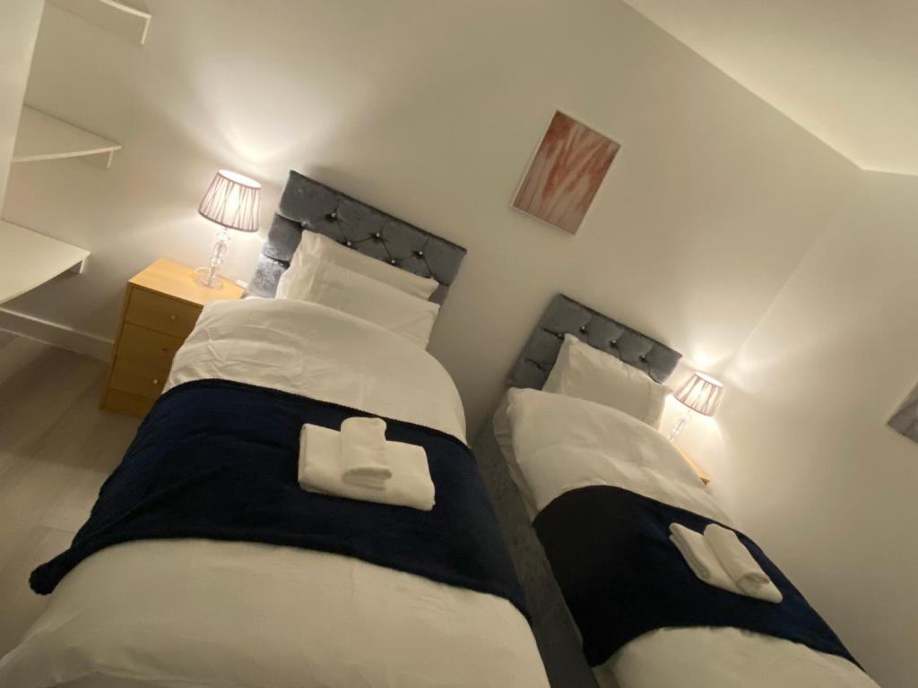 a bedroom with two beds and a night stand with lamps at Relaxing Modern Apartment, Sheffield, Free Parking in Sheffield