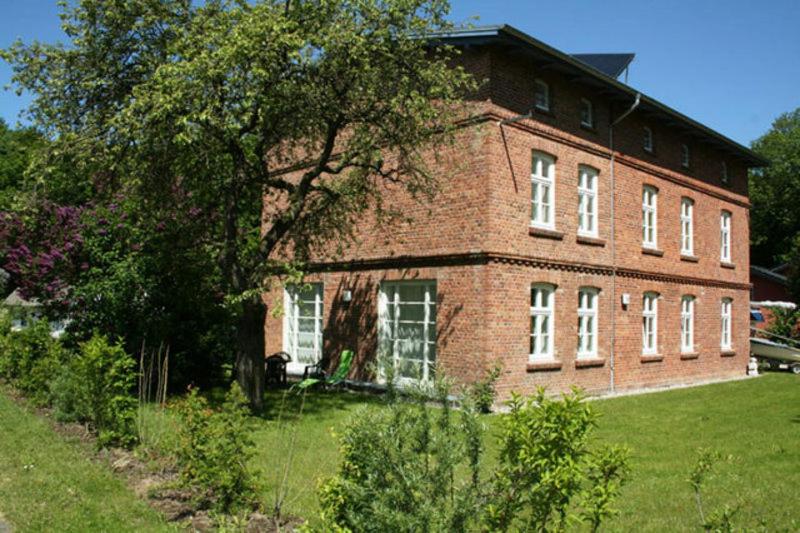 ein großes Backsteingebäude mit einem Baum davor in der Unterkunft Ferienwohnungen in Klausdorf in Klausdorf