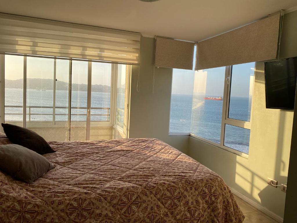 a bedroom with a bed with a view of the ocean at Condominio Costa Peñuelas in Coquimbo