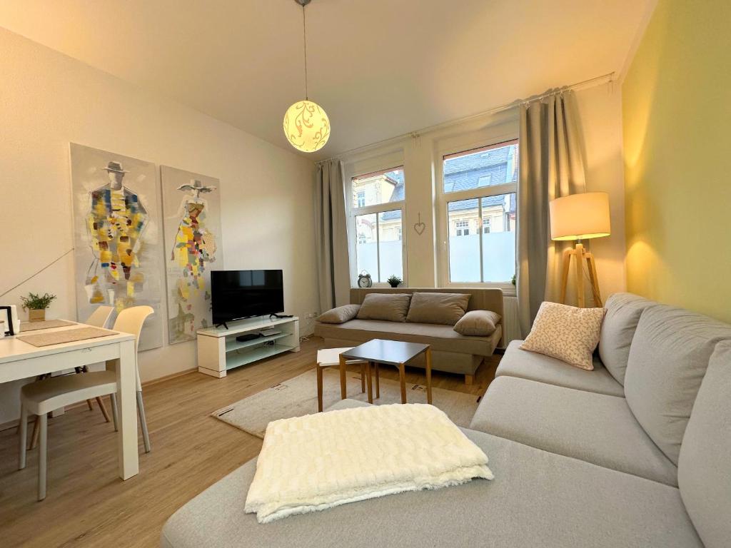 Stilvolle, charmante Ferienwohnung in Plauen في بلاوين: غرفة معيشة مع أريكة وطاولة