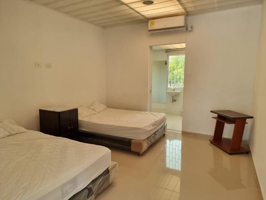 a room with two beds and a table in it at PLAYABRISAMAR in San Antero