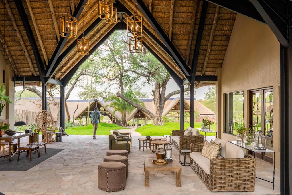 an open living room with chairs and tables at Thornybush Game Lodge in Thornybush Game Reserve