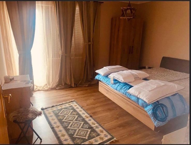 een slaapkamer met een bed, een tapijt en een raam bij Vila Vanilla 